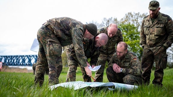 Soldaten der Bundeswehr besprechen sich, vor der Suche am Ufer der Oste. 