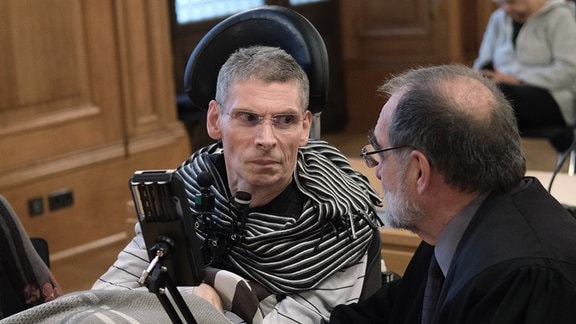 Harald Mayer (l), durch Multiple Sklerose komplett bewegungsunfähig, sitzt neben Robert Roßbauch, Rechtsanwalt, in einem Saal des Bundesverwaltungsgerichtes.