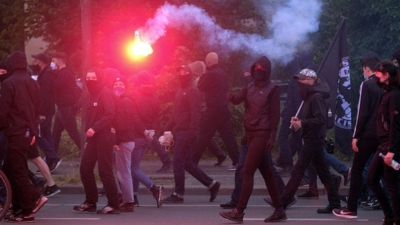Teilnehmer einer Demonstration laufen durch Connewitz und zünden Pyrotechnik. 
