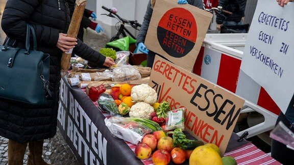 Klimaaktivisten verteilen an Passanten weggeworfene Lebensmittel, welche sie aus Containern gerettet haben. 