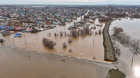 Ein Fluss ist übers Ufer getreten und überschwemmt eine Stadt.