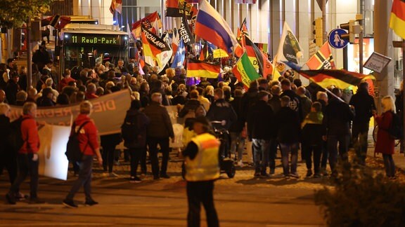 Teilnehmer einer Demonstration gegen die Energiepolitik der Bundesregierung und gegen Coronamaßnahmen laufen am Abend durch die Innenstadt von Gera.