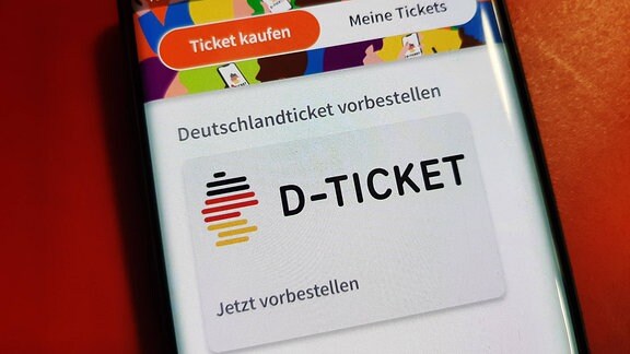 Der Bildschirm eines Mobiltelefons zeigt das Logo des "Deutschlandtickets".