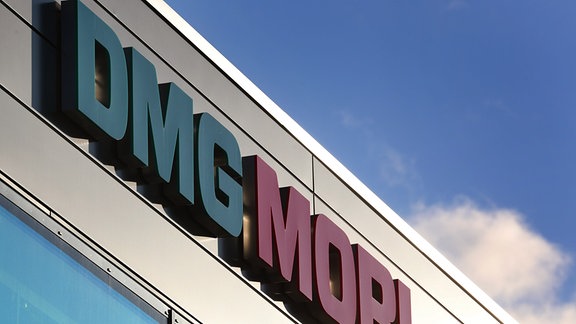 Das Logo des Unternehmens DMG Mori an einer Gebüdefassade