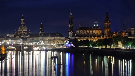 Die historische Altstadtkulisse mit der Frauenkirche (l-r), dem Ständehaus, der Hofkirche, dem Rathaus, dem Hausmannsturm und dem dem Residenzschloss wird am Abend nicht mehr beleuchtet, nur noch die Lichter der Straßenbeleuchtung auf der Augustusbrücke reflektieren sich in der Elbe. 