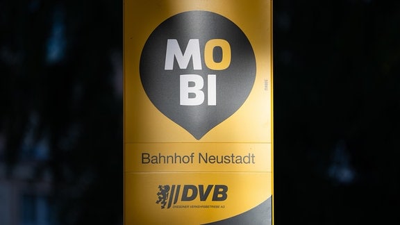 Ein Schild "Mobi" steht vor dem Bahnhof Neustadt an einer Haltestelle des Shuttle-Service der Dresdner Verkehrsbetriebe.