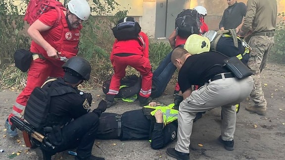 Auf diesem vom ukrainischen Rettungsdienst zur Verfügung gestellten Foto leisten Sanitäter Erste Hilfe für verletzte Mitarbeiter des Rettungsdienstes nach russischen Angriffen auf ein medizinisches Zentrum in der nordostukrainischen Stadt Sumy.