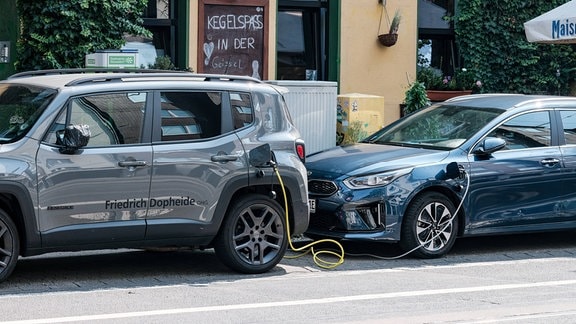 Zwei parkende E-Autos sind miteinander verbunden.