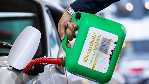 Ein Auto wird mit einem Kanister mit der Aufschrift «Klimaschutz könnte man Tanken - E-Fules for Future» an einer Tankstelle während einer E-Fuels-Probefahrt im Rahmen der Stuttgarter Mobilitätswoche mit E-Fule betankt.