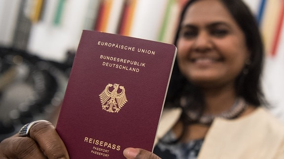 Mridula Singh, die aus Indien stammt, hält am 23.01.2018 nach der Einbürgerungsfeier für mehr fast 2200 Menschen in der Paulskirche in Frankfurt am Main (Hessen) ihren Pass in die Kamera