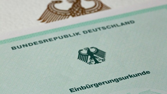 Eine Einbürgerungsurkunde der Bundesrepublik Deutschland liegt auf einem Tisch.