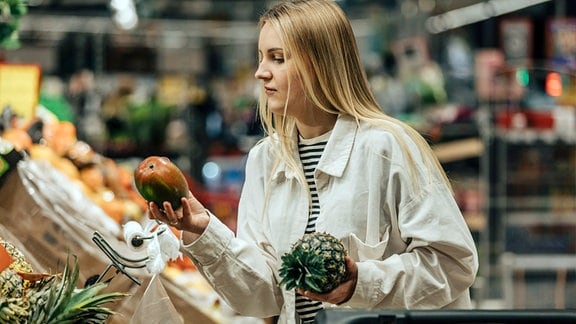 Eine Frau in der Obst- und Gemüseabteilung im Supermarkt