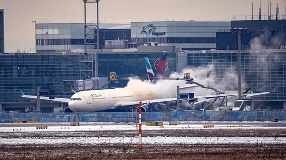 Winter am Flughafen Frankfurt Ein Flieger wird am Terminal enteist.