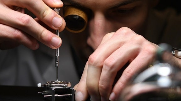 Ein Uhrmacher montiert eine Jubiläumsuhr der Marke Union Glashütte. 