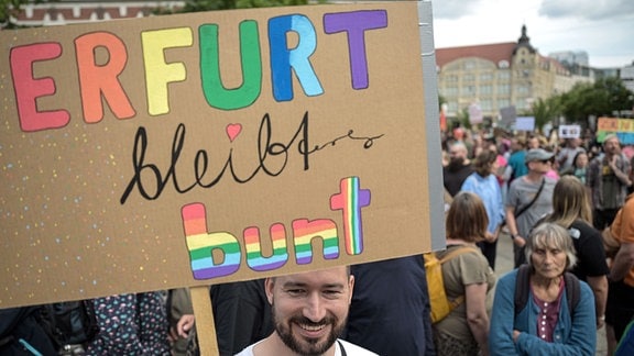 Ein Demonstrant hält ein Schild mit der Aufschrift «Erfurt bleibt bunt». 