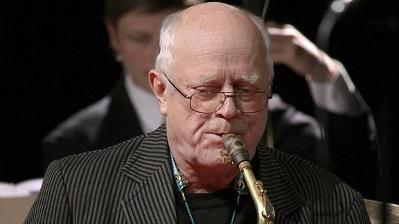 Ernst-Ludwig Petrowsky, ein Mann mit Brille spielt Saxophon.