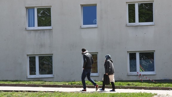 Asylbewerber gehen auf dem Gelände der Erstaufnahmeeinrichtung des Landes Thüringen spazieren. 