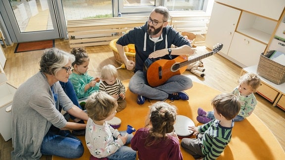 Kinder und Erzieher beim singen.