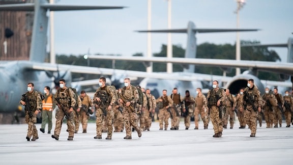 Soldaten steigen aus den Transportflugzeugen A400M der Bundeswehr und einem Airbus A310 der Luftwaffe, nach der Landung auf dem niedersächsischen Stützpunkt Wunstorf