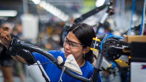 Mitarbeiterin arbeitet in der Diamant Fahrradwerke GmbH an einem Fahrrad.