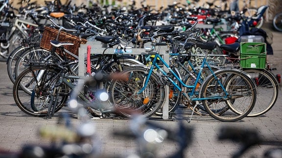 Zahllose Fahrräder stehen angeschlossen vor einem Hauptbahnhof