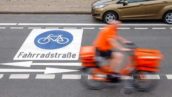 Fahrradfahrer fahren auf neuer Fahrradstrasse mit frisch aufgebrachten Piktogrammen, hier die Kahrstrasse im Stadtteil Holsterhausen. 