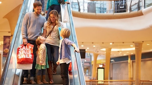 Familie bei Einkaufsbummel auf einer Rolltreppe, 2014