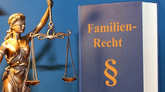 Symbolbild Fachbuch Familienrecht und eine Justitia