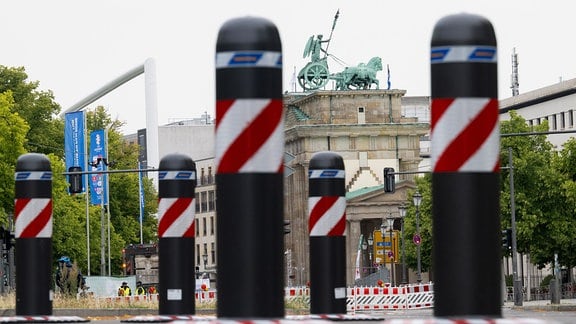 Mobile Poller mit rot-weißer Markierung sind als Absperrung zur Fanzone am Brandenburger Tor aufgestellt.