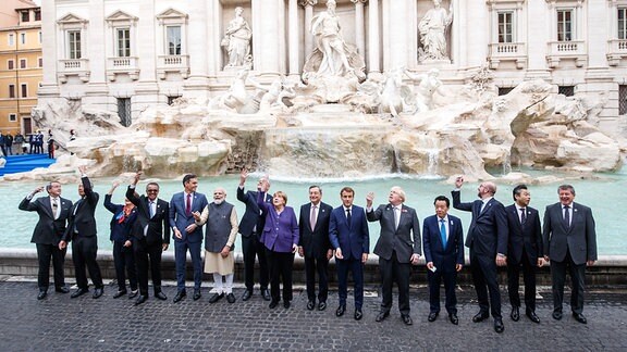Die Staats- und Regierungschefs stehen im Rahmen eins G20-Gipfels vor dem Trevi-Brunnen im Rom und werfen eine Münze in den Brunnen hinter ihnen