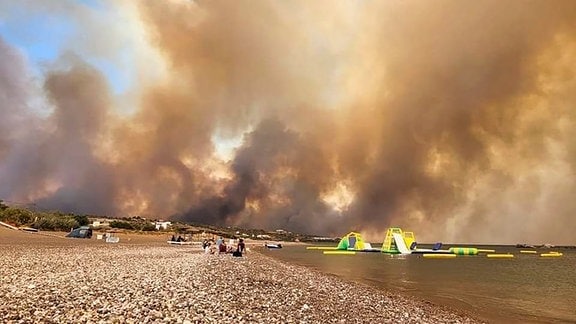 Dichte Rauchwolken eines Waldbrandes steigen auf der griechischen Insel Rhodos in den Himmel. 