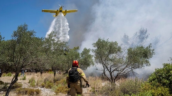 Ein Flugzeug wirft Wasser über einem Waldbrand beim Dorf Vati ab. Starke Winde erschweren den Kampf gegen die Waldbrände auf der griechischen Ferieninsel Rhodos. 