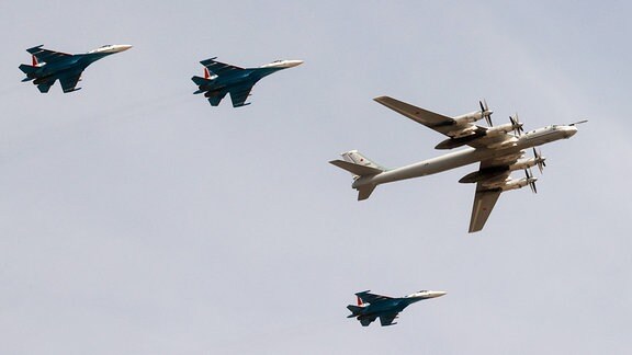 Suchoi Su-35-Kampfflugzeuge bekleiten ein russisches Kampfflugzeug Tupolew Tu-95