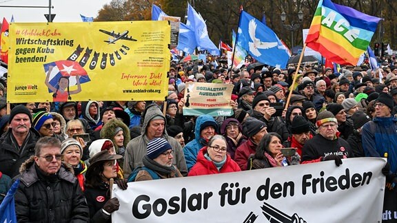 Teilnehmer einer Friedensdemonstration verschiedener Initiativen auf dem Platz des 18. März halten unter anderem ein Transparent mit der Aufschrift "Goslar für den Frieden".