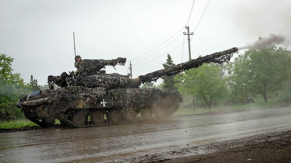 Ukrainische Soldaten feuern von einem ukrainischen Panzer an der Front in der Nähe von Bachmut in der Region Donezk auf russische Stellungen.