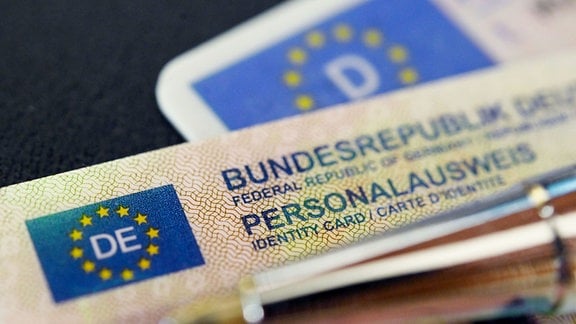 Ein Personalausweis der Bundesrepublik Deutschland liegt auf einem Führerschein.
