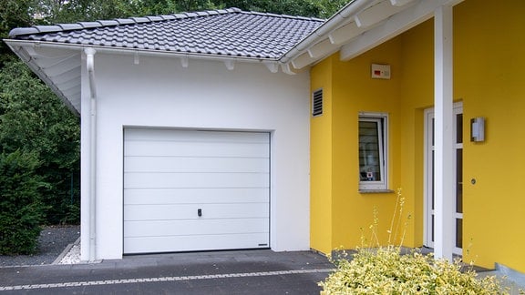 Ein Garagentor neben einer gelben Hauswand.