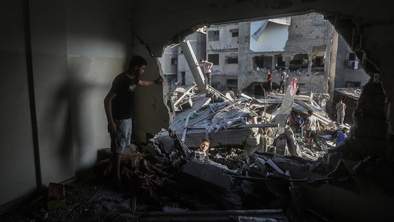 Palästinenser suchen nach israelischen Angriffen in einem eingestürzten Gebäude nach Ãberlebenden.