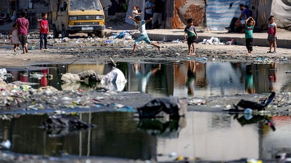 Vertriebene Kinder spielen neben Abwasser in den Straßen von Deir al-Balah im zentralen Gazastreifen.