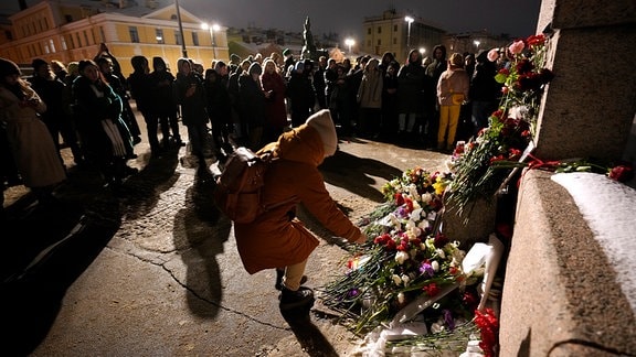 Menschen versammeln sich, um Blumen für den russischen Oppositionellen Nawalny niederzulegen, an einem Denkmal für die Opfer politischer Repressionen.