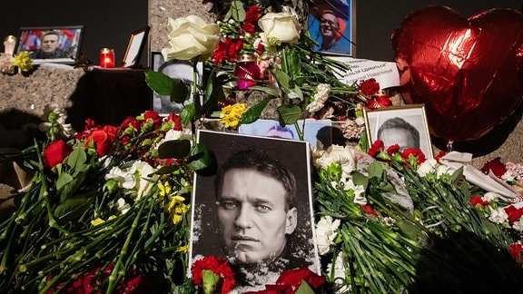 Fotos, Blumen und Kerzen zum Gedenken an den verstorbenen russischen Oppositionellen Nawalny wurden in St Petersburg am Denkmal für die Opfer politischer Repressionen abgelegt.