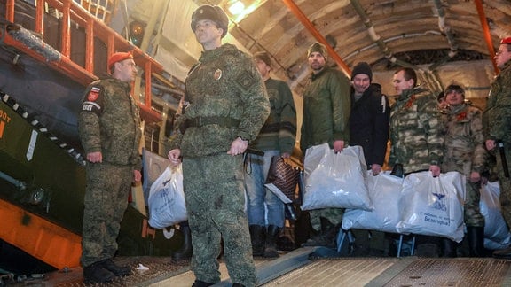 Russische Soldaten, die nach einem Gefangenenaustausch mit der Ukraine aus der Gefangenschaft entlassen wurden, steigen nach der Landung aus ihrem Flugzeug aus.