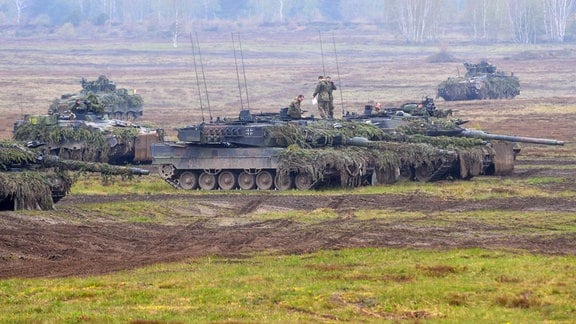 Soldaten des Panzerbataillons 414 stehen auf dem Truppenübungsplatz des Gefechtsübungszentrum des Heeres in der Colbitz-Letzlinger Heide nach einer Übung auf ihren ihre Kampfpanzern vom Typ Leopard II.