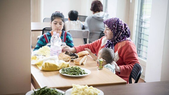 Flüchtlinge essen am Dienstag (29.03.16) in Berlin in der Unterkunft für Flüchtlinge des Vereins Christliches Jugenddorfwerk Deutschland Mittag.