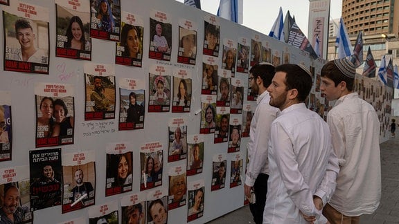 Israelis betrachten Fotos von Menschen, die im Gazastreifen vermisst und gefangen gehalten werden.