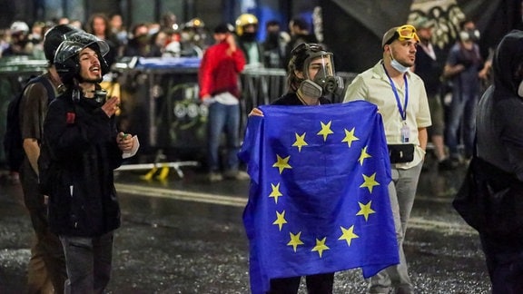 Ein Demonstrant steht mit einer EU-Flagge vor einer Polizeisperre während eines Protestes der Opposition gegen das "russische Gesetz" in der Nähe des Parlamentsgebäudes in Tiflis, Georgien.