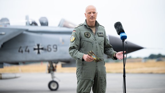 Ingo Gerhartz, Inspekteur der Luftwaffe, spricht während eines Pressetermins zum Abschluss des Luftwaffen-Manöver Air Defender 2023 auf dem Luftwaffenstützpunkt in Jagel, hinter ihm steht ein Tornado der deutschen Luftwaffe. 