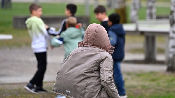 Schüler halten sich in der grossen Pause auf dem Schulhof einer Grundschule auf und tollen herum.