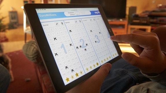 Ein Lottospieler platziert seinen Einsatz auf einem Tablet-Computer. 