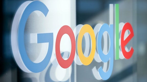 Ein Schriftzug mit dem Logo von Google klebt im Pressezentrum der Koelnmesse auf einer Glasscheibe